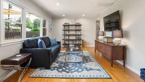 A modern living room with a sofa, coffee table, and bookshelf. - Southern Hills Stunner! 3bd/2bth (Tulsa)