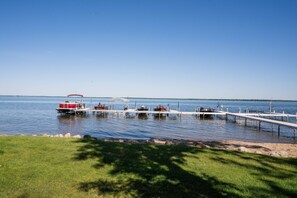 Enjoy serene lakeside views from the dock, where boats are moored in the calm waters.