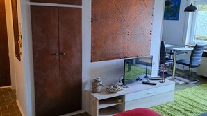 A bedroom with a bed, a TV, a desk, and a chair.