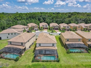 A residential area with multiple houses, a central road, and a swimming pool area.