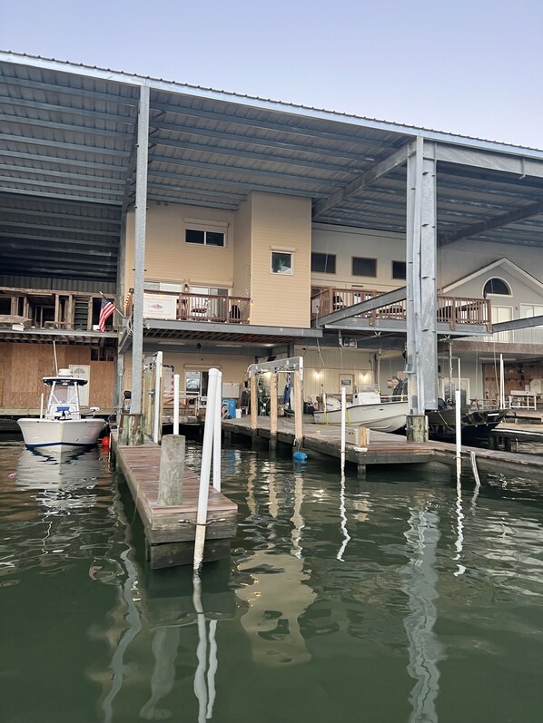 A marina with docked boats, a covered building with multiple levels, and a flagpole with an American flag.