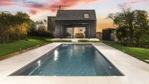 A modern house with a swimming pool, a covered outdoor seating area, and a view of the sunset. - Westaway House in Trelights near Port Isaac (Port Isaac)