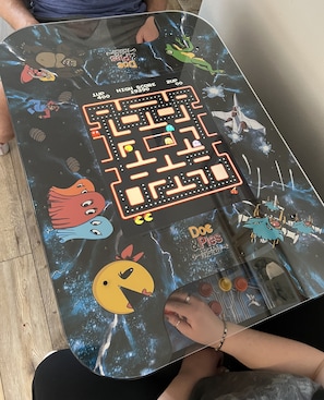 A table with a maze game featuring Doc & Pup characters and arcade-style graphics.