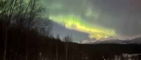A snowy landscape with a view of the aurora borealis.