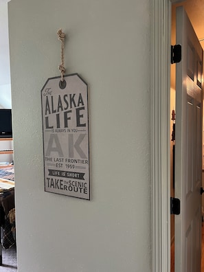 Een muur met een bord waarop staat 'The Alaska Life' en 'The Last Frontier' en een jaartal 'EST 1959'.