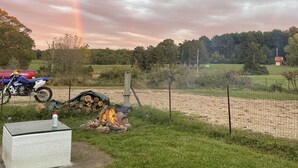 A grassy area with a dirt path, a fire pit, and a motorcycle. - Hollering Pines Retreat-Great for Military, Fugitive Beach, in Mark Twain Forest (Newburg)