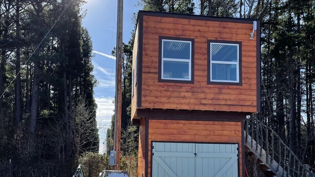 A wooden cabin with a garage, surrounded by tall trees and snow on the ground. - Hollering Pines Retreat-Great for Military, Fugitive Beach, in Mark Twain Forest (Newburg)