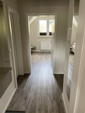 Käytävän päästä on pääsy makuuhuoneeseen, jossa on ikkuna, patteri ja puhelin.