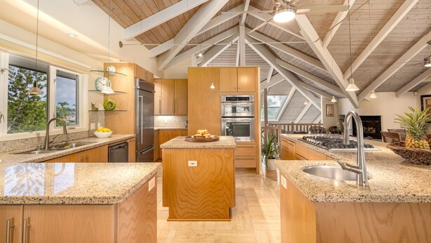 Una cocina moderna con encimeras de granito, armarios de madera y una isla central.