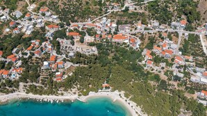 An aerial view of a coastal town with residential buildings, a beach, and a clear blue sea. - Villa Seraphine with Pool (Brela)