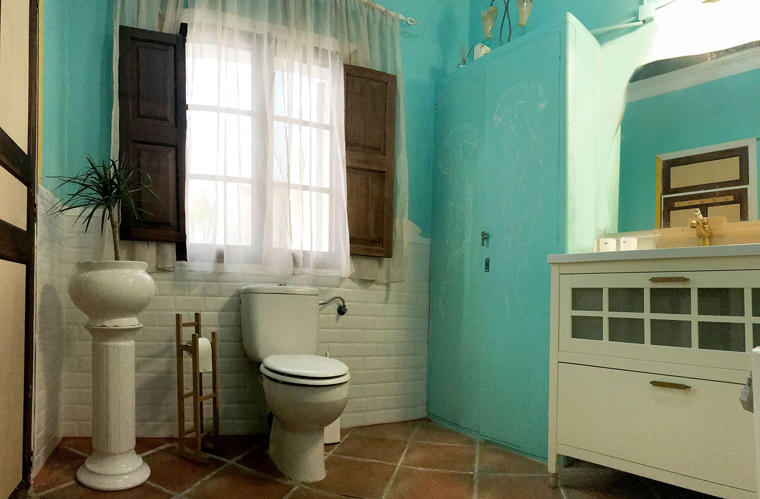Un bany amb vàter, un lavabo i un mirall.