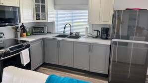 Een moderne keuken met roestvrijstalen apparatuur, een inbouwoven, een magnetron, een broodrooster en een koelkast.