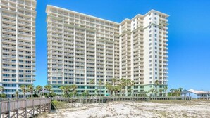 A beachfront hotel with multiple high-rise buildings, a sandy beach, and a wooden boardwalk. - Beach Club A1406: K/Q,TT,sofa sleeper Direct Gulf View-Pack n Play - Pools/Beach (Gulf Shores)