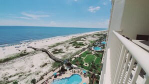 A beach resort with a pool area, a boardwalk, and a view of the ocean. - Beach Club A1406: K/Q,TT,sofa sleeper Direct Gulf View-Pack n Play - Pools/Beach (Gulf Shores)