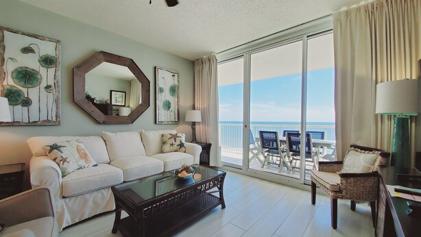 A living room with a sofa, coffee table, and a view of the ocean through large sliding doors. - Beach Club A1406: K/Q,TT,sofa sleeper Direct Gulf View-Pack n Play - Pools/Beach (Gulf Shores)