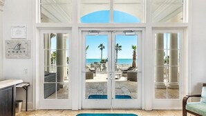A hotel entrance with a view of the beach, a reception desk, and a blue mat with "The Beach Club by Spectrum Resorts" text. - Beach Club A1406: K/Q,TT,sofa sleeper Direct Gulf View-Pack n Play - Pools/Beach (Gulf Shores)