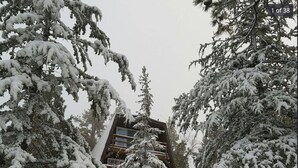 Een gebouw bedekt met sneeuw, met een houten trap die naar een deur leidt.