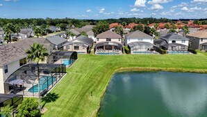 Bairro residencial com casas, piscina e lago.