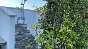 A rooftop with a built-in shower, a small staircase, and a dense green bush. - New Superior Apartment all comfort reserved 5 min sea 25 min airport (Budoni)