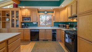 A kitchen with wooden cabinets, a stove, a microwave, and a dishwasher.