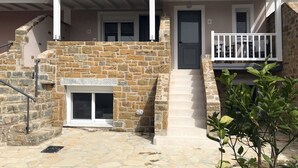 Ein Steinhaus mit Veranda, Treppe und kleinem Balkon.
