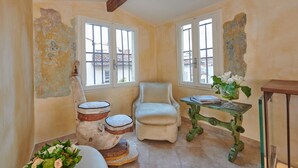 A room with a chair, a small table, and a vase with flowers. - Apartment Leoni Suite in Florence by Mmega (Firenze)