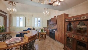 A kitchen with wooden cabinets, a stove, and a chandelier. - Apartment Leoni Suite in Florence by Mmega (Firenze)