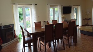 A dining area with a table and chairs, a fireplace, and a television mounted on the wall.