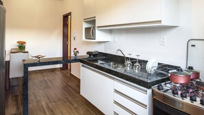 Una cocina moderna con encimera de granito, electrodomésticos de acero inoxidable y armarios blancos.