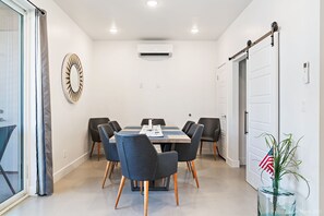 A modern dining room with a rectangular table, six chairs, and a decorative wall piece. - Abbys Retreat At Green Valley (St. George)