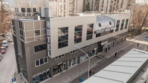 A hotel with a modern design, featuring large windows and a prominent sign. - Concept Hotel Central (Skopje)