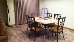 A dining area with a round table, six chairs, a lamp, and a window with curtains. - Condos.  hot tub, deck,  Patoka lake (8800 acres) boating and beach, concessions   (French Lick)