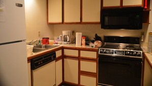 A compact kitchen with a refrigerator, microwave, stove, and sink. - Condos.  hot tub, deck,  Patoka lake (8800 acres) boating and beach, concessions   (French Lick)