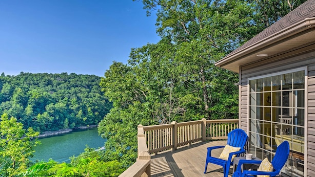 A wooden deck with blue chairs and a glass door, overlooking a river and forested area. - Luxe Lake Cumberland Retreat w/ Decks on 1 Acre! (Jamestown)