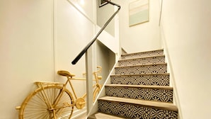 Un escalier aux marches décorées et un vélo appuyé contre le mur.