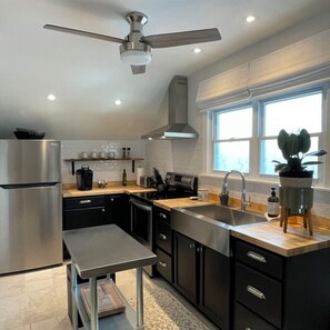 Enjoy cooking in this well-lit kitchen with a large island, oven, and sleek refrigerator.