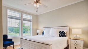 A bedroom with a large bed, a nightstand, a chair, and a ceiling fan. - *NEW* - LOCATION, LOCATION - 250 Feet to the Beach - Sleeps 6 (Bay St Louis)