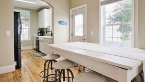 A kitchen with a long white table, bar stools, and a 'Welcome' sign. - *NEW* - LOCATION, LOCATION - 250 Feet to the Beach - Sleeps 6 (Bay St Louis)