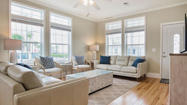 A spacious living room with a beige sofa, a patterned coffee table, and a white armchair. - *NEW* - LOCATION, LOCATION - 250 Feet to the Beach - Sleeps 6 (Bay St Louis)