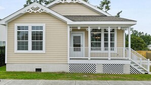 A single-story house with a front porch, a small staircase, and a garage. - *NEW* - LOCATION, LOCATION - 250 Feet to the Beach - Sleeps 6 (Bay St Louis)