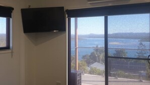 Une pièce dotée d’une grande porte-fenêtre coulissante donnant sur un balcon avec vue sur la mer.