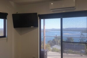A room with a large sliding glass door leading to a balcony with a view of the sea. - Sunset Beach House 1770 Level 3 (Seventeen Seventy)