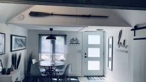Una cocina moderna con una isla central, un área de comedor con una mesa redonda y sillas, y un ventanal que proporciona luz natural.
