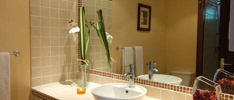 A bathroom with a large mirror, a sink, and a toilet.