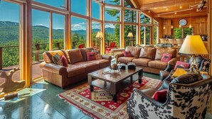 Un soggiorno spazioso con ampie finestre, soffitto in legno e vista sulle montagne.