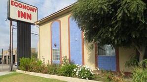 A building with a sign reading "Economy Inn" and a large window with a brick facade.