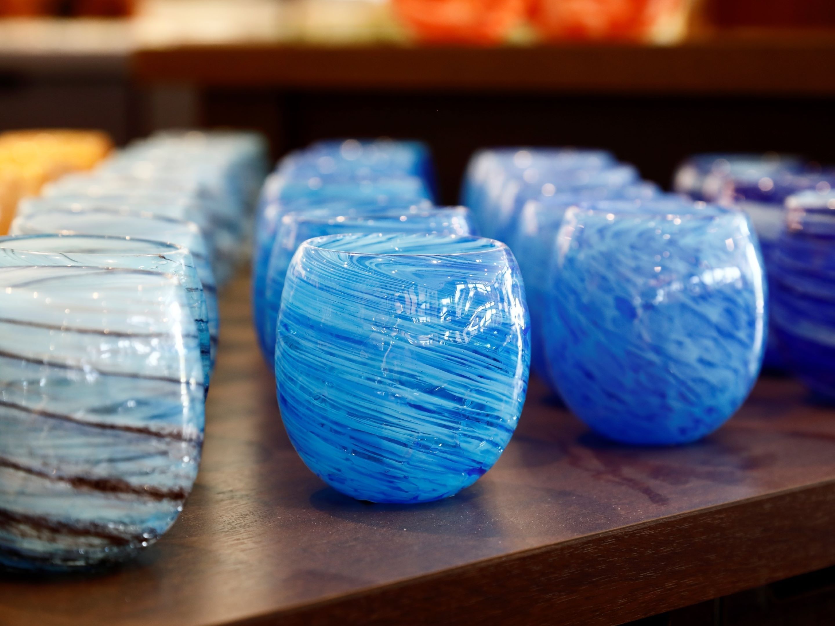 A row of glass vases on a wooden surface.