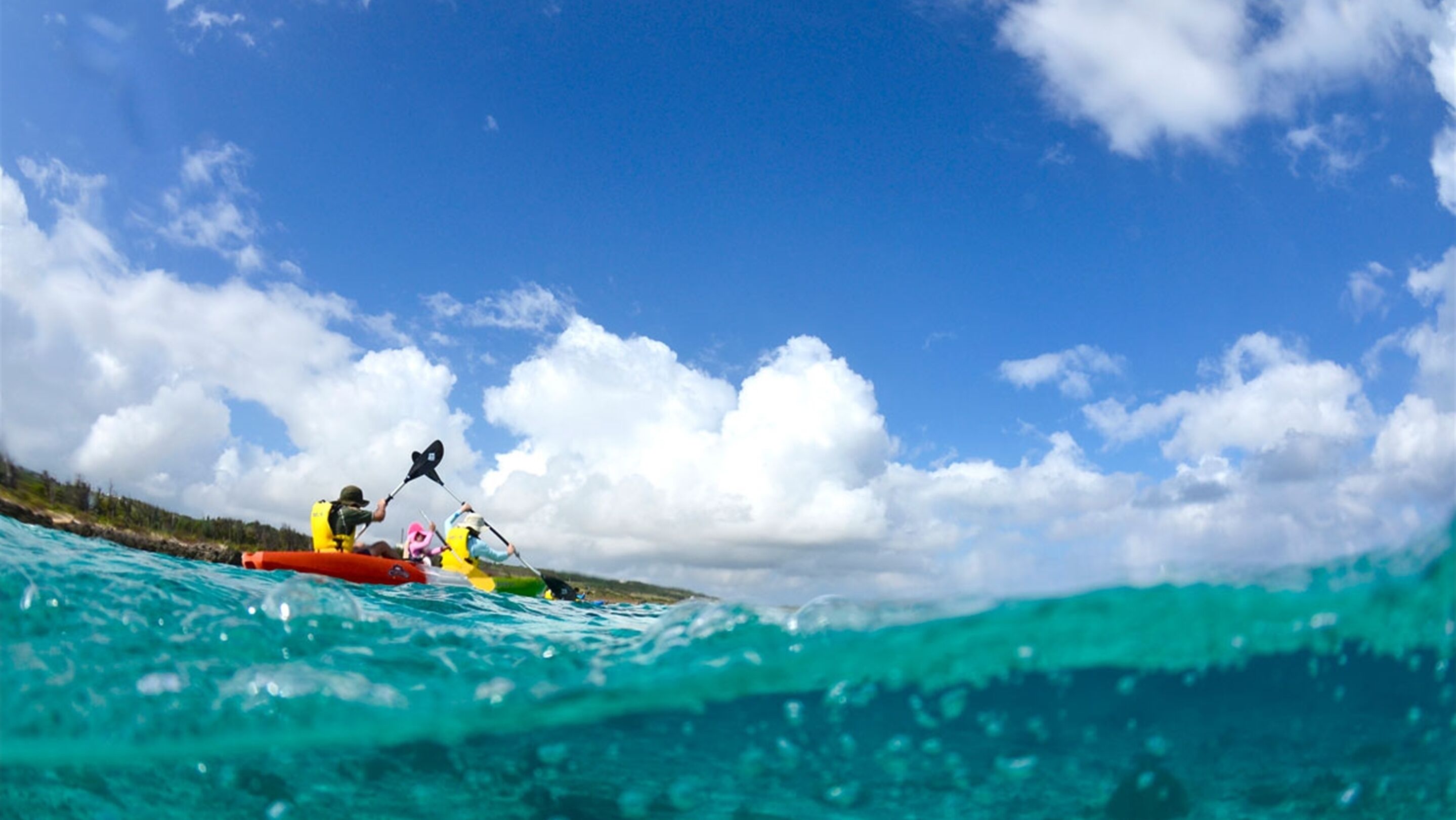 Vista clara de un kayak en agua turquesa con cielo parcialmente nublado.