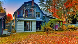 A two-story house with a balcony, surrounded by autumn foliage. - Family Winter House in the ❤️ of the Eastern Townships (Ayer's Cliff)