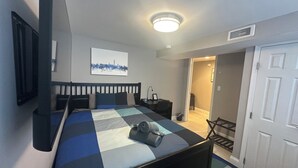 Ein Schlafzimmer mit Bett, Schreibtisch, Stuhl und Tür.